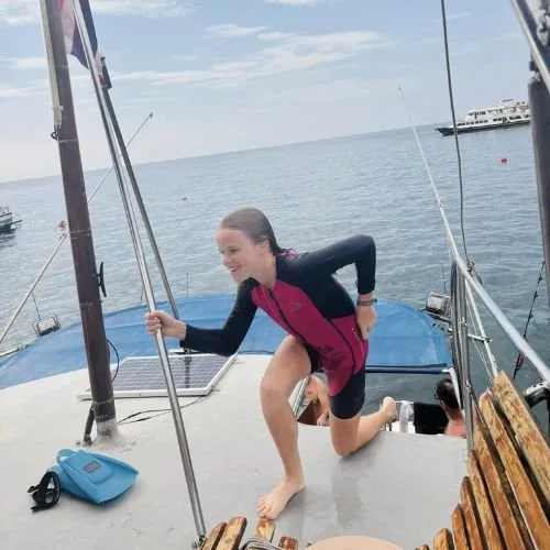 Jeune femme souriante sur le pont d'un bateau de plongée en mer