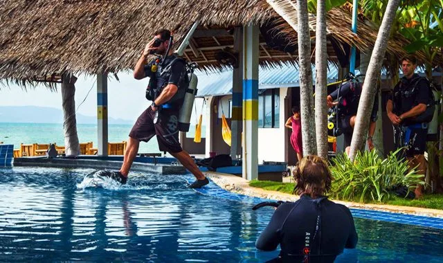 Plongeurs s'équipent près d'une piscine avec un instructeur