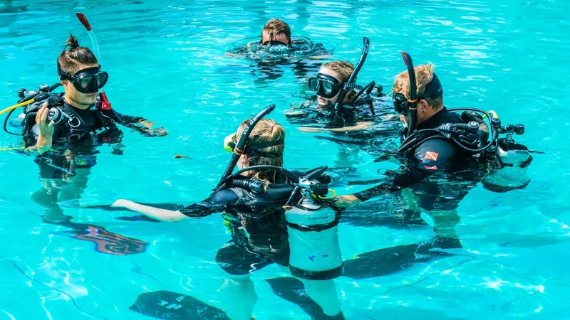 Plongeurs en formation dans une piscine, vérification du matériel