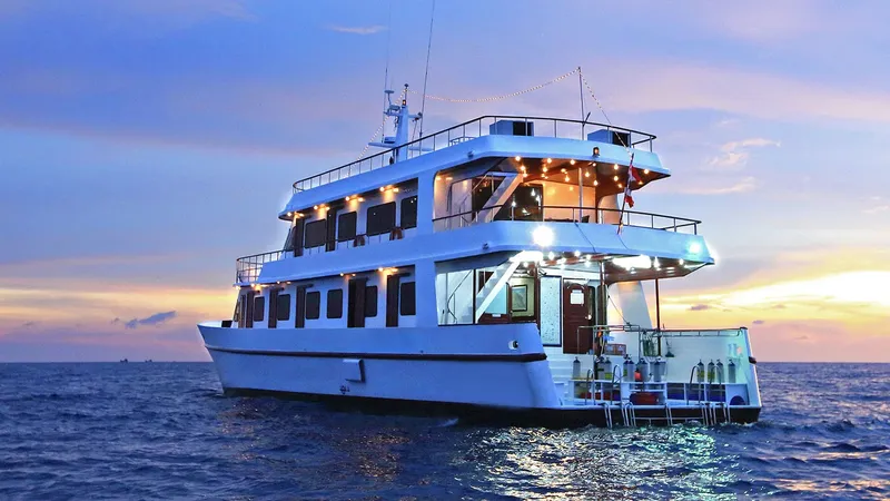 Grand bateau de plongée blanc sur l'eau au coucher du soleil