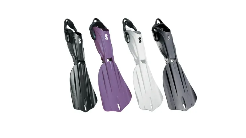 Quatre paires de palmes de plongée de différentes couleurs sur fond blanc