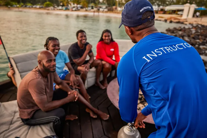 Groupe de personnes sur un bateau de plongée avec un instructeur