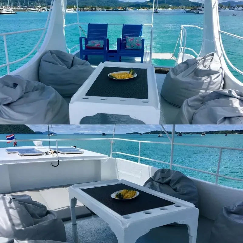 Vue d'un bateau avec des fauteuils, une table et la mer turquoise