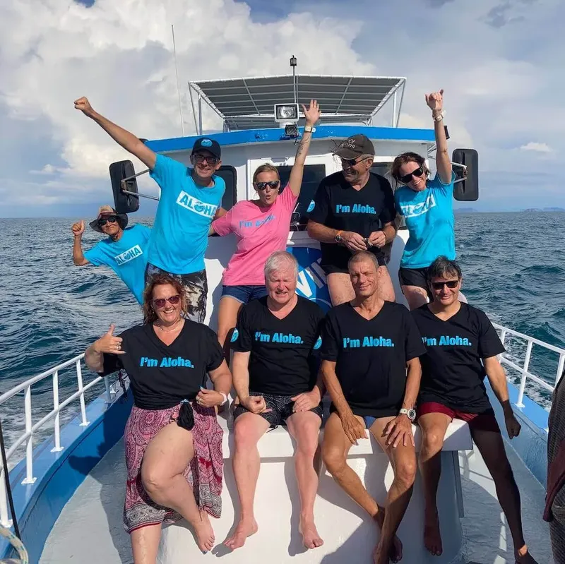 Groupe de personnes souriantes sur un bateau en mer, ambiance joyeuse