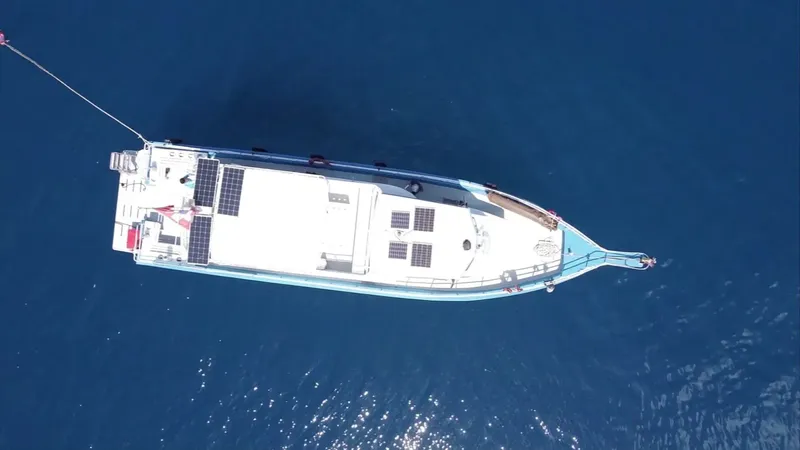 Vue aérienne d'un bateau de plongée blanc sur mer bleue calme