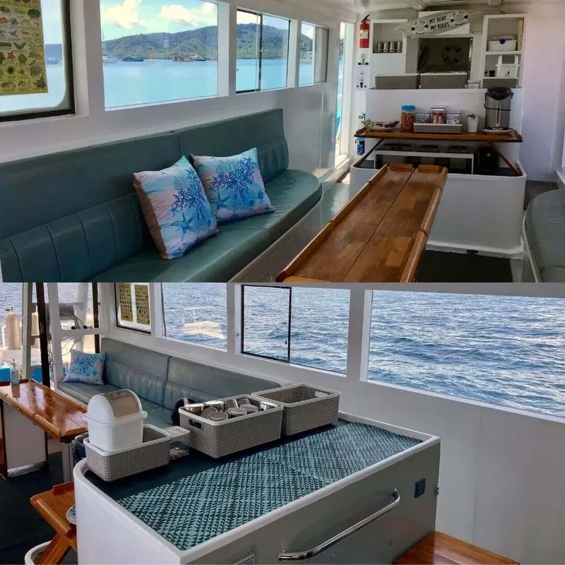 Intérieur d'un bateau de plongée avec banquettes, table et cuisine équipée
