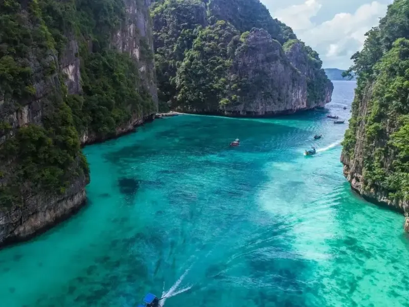 Vue aérienne d'une lagune turquoise avec des bateaux et falaises