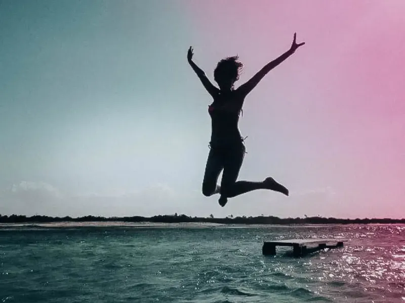 Saut d'une personne dans l'eau depuis une plateforme flottante