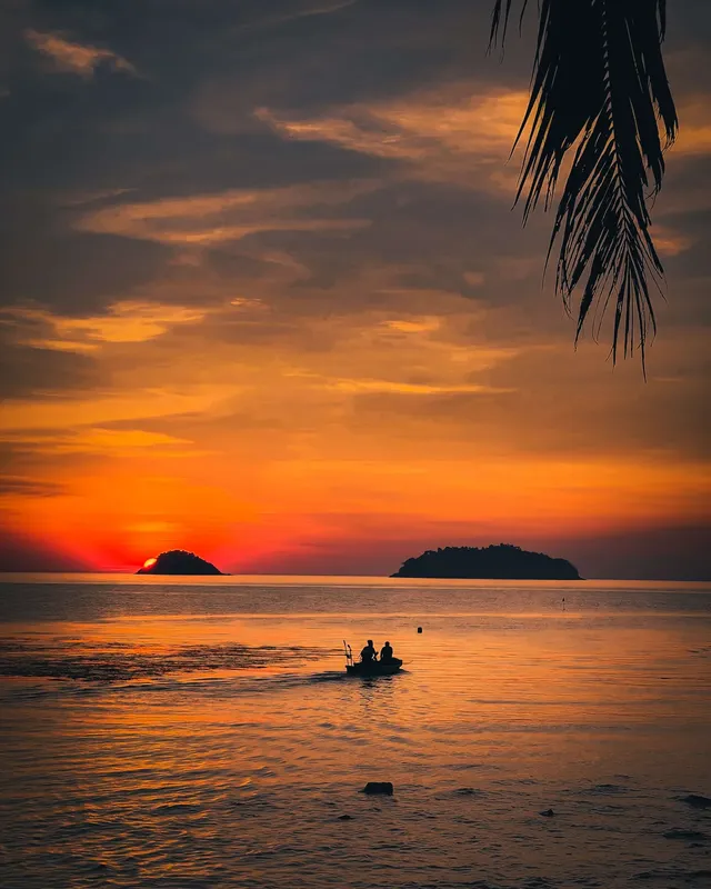 Coucher de soleil sur mer avec deux personnes en bateau pneumatique