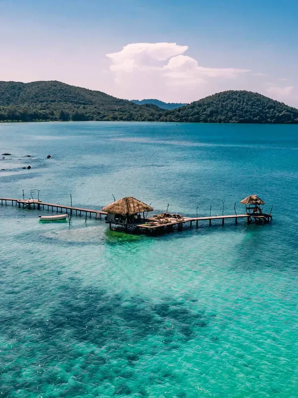 Vue aérienne d'un ponton en bois sur une eau turquoise claire