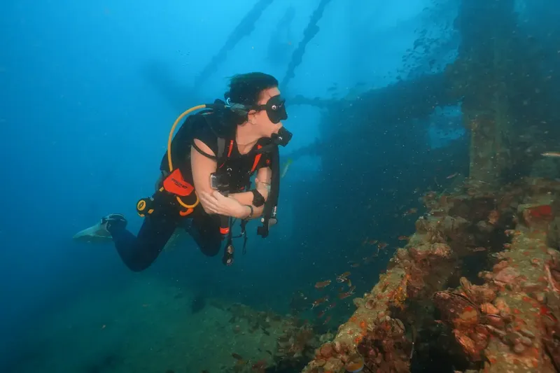 Plongeur explore une épave sous-marine avec équipement complet