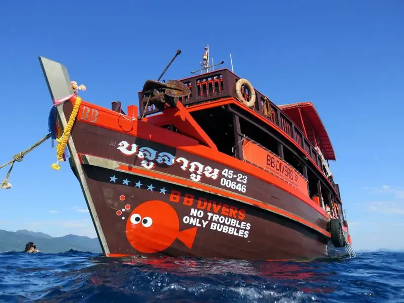Bateau de plongée rouge et jaune sur une mer bleue calme