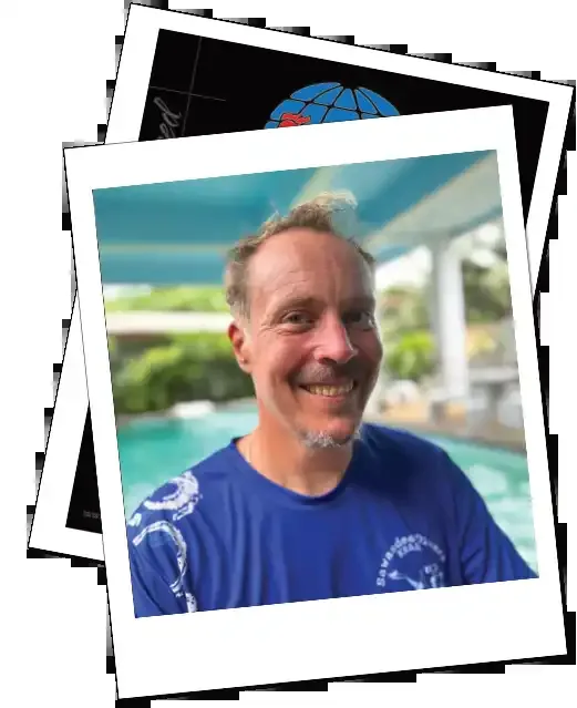Portrait souriant d'un homme devant un fond flou de végétation
