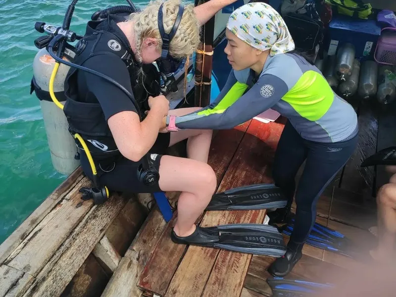 Deux plongeuses s'équipent sur un bateau en préparation d'une plongée