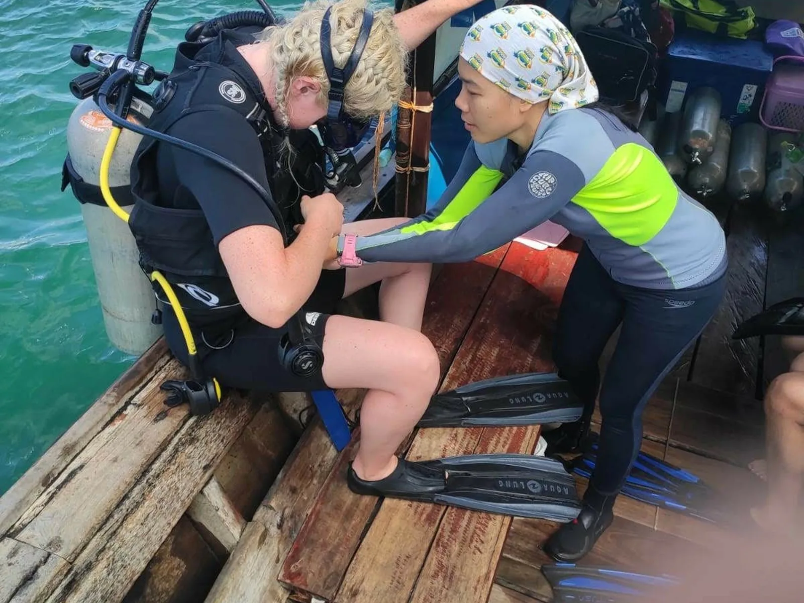 Deux plongeuses s'équipent sur un bateau en préparation d'une plongée