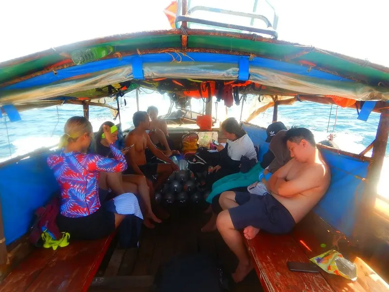 Plongeurs assis dans un bateau, équipement de plongée visible