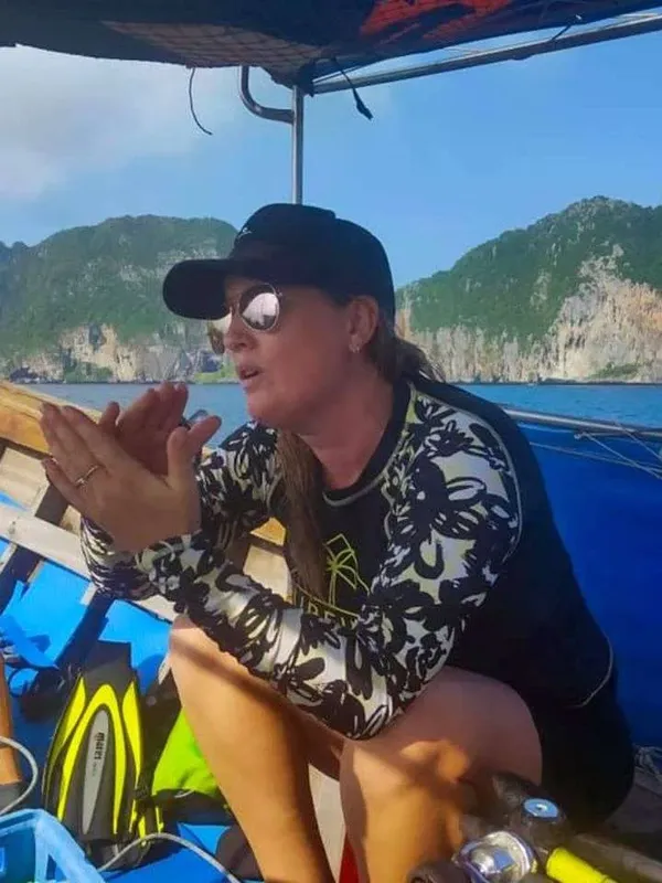 Femme souriante sur un bateau de plongée, prête pour l'aventure
