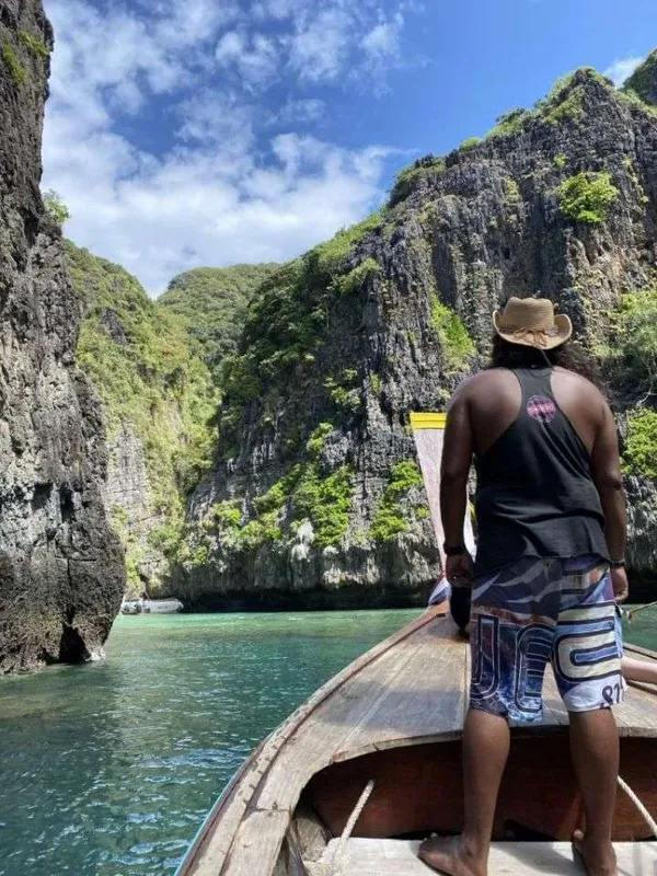 Personne à l'arrière d'un bateau, regardant un paysage rocheux tropical