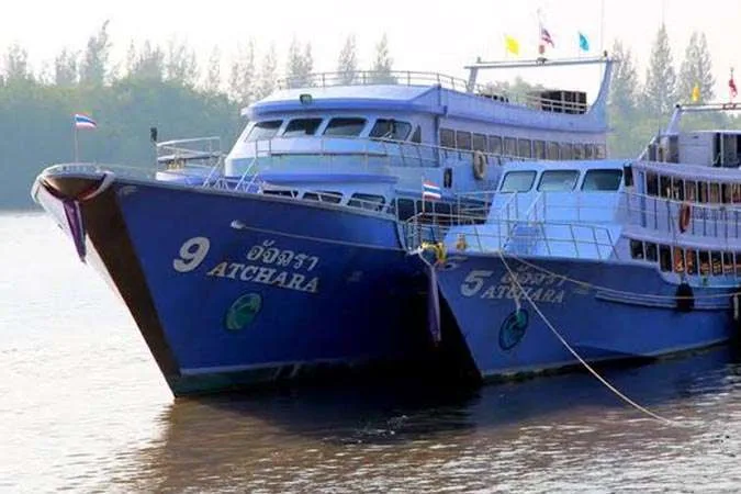 Deux bateaux de plongée bleus amarrés dans une eau calme