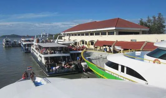 Plusieurs bateaux amarrés devant un bâtiment avec des personnes à bord