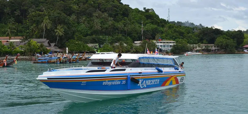 Bateau rapide bleu et blanc navigue sur une mer calme et turquoise