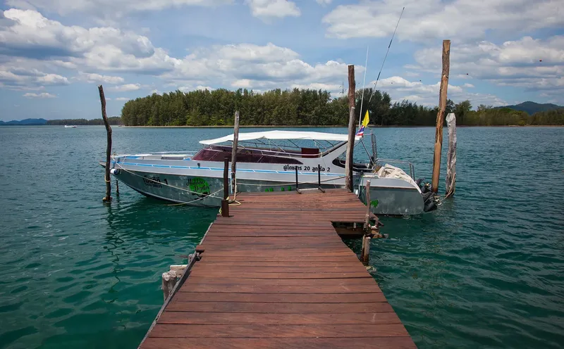 Bateau de plongée amarré à un ponton en bois sur l'eau