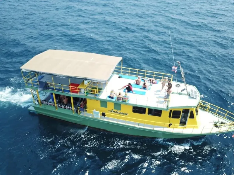 Bateau de plongée jaune avec des passagers, naviguant sur une mer bleue