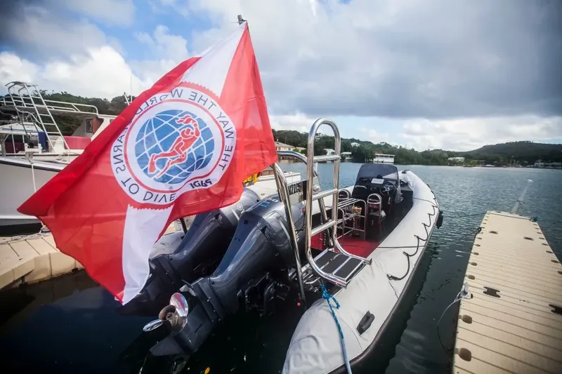 Bateau de plongée amarré à un ponton avec un drapeau coloré