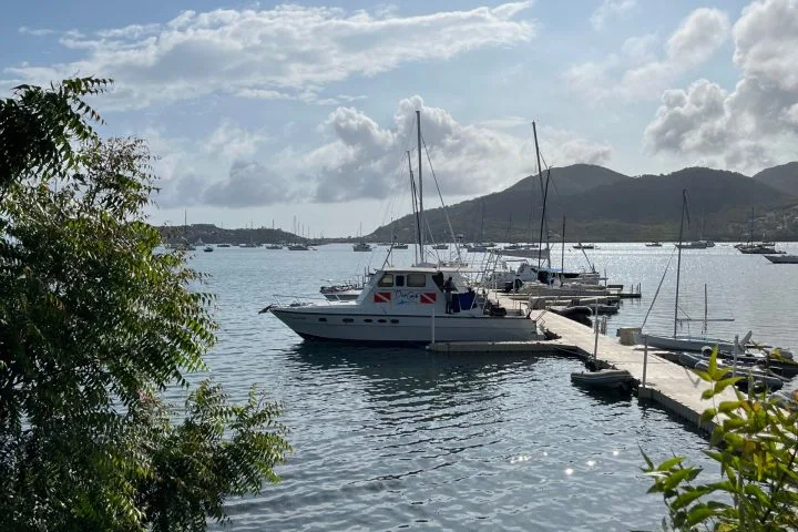 Bateau de plongée amarré à un ponton avec des personnes à bord