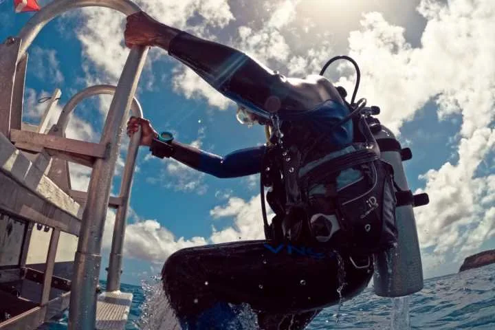 Plongeur s'apprête à entrer dans l'eau depuis un bateau de plongée