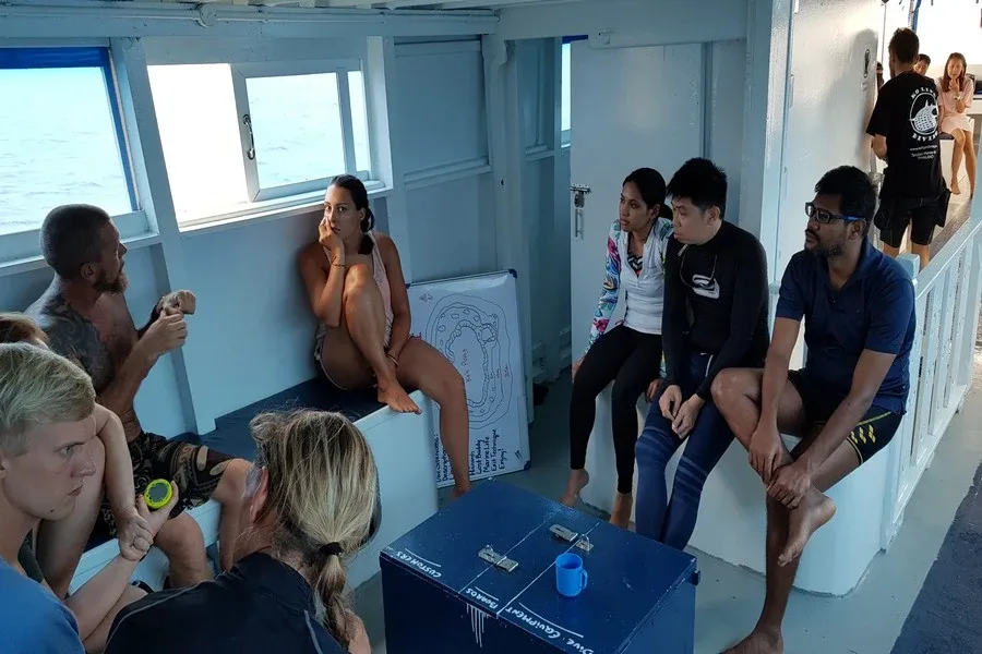 Groupe de personnes discutant sur le pont d'un bateau de plongée