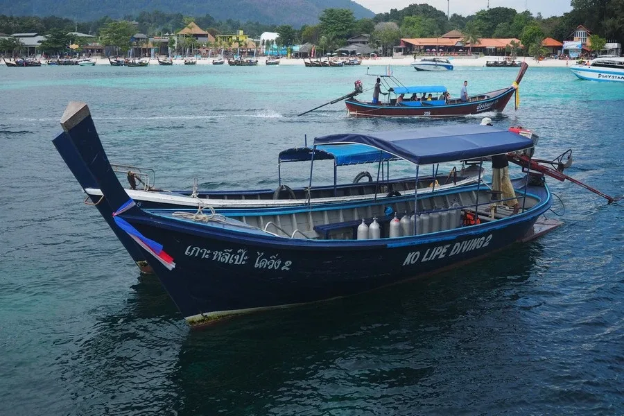 Bateau de plongée bleu avec des bouteilles et des passagers à bord