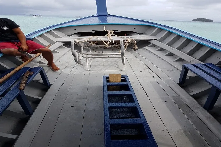 Intérieur d'un bateau de plongée avec une personne assise à l'avant