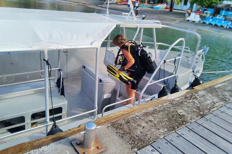 Plongeur s'équipant sur un bateau de plongée au ponton