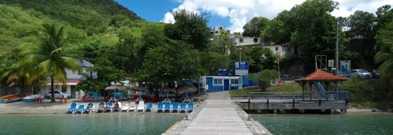 Centre de plongée avec ponton, transats et bâtiments sur la côte