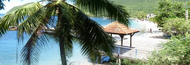 Vue d'une plage avec des transats, un abri et des bateaux amarrés