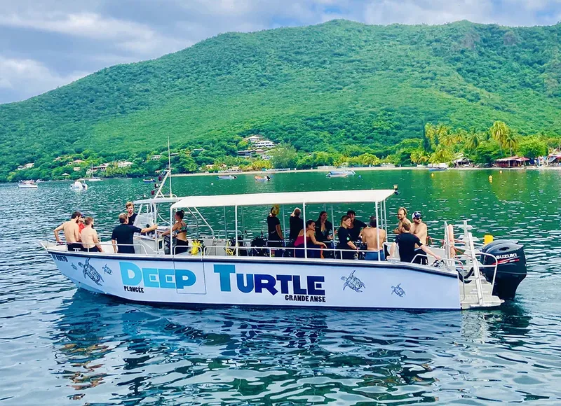Bateau de plongée rempli de personnes sur une eau turquoise et calme