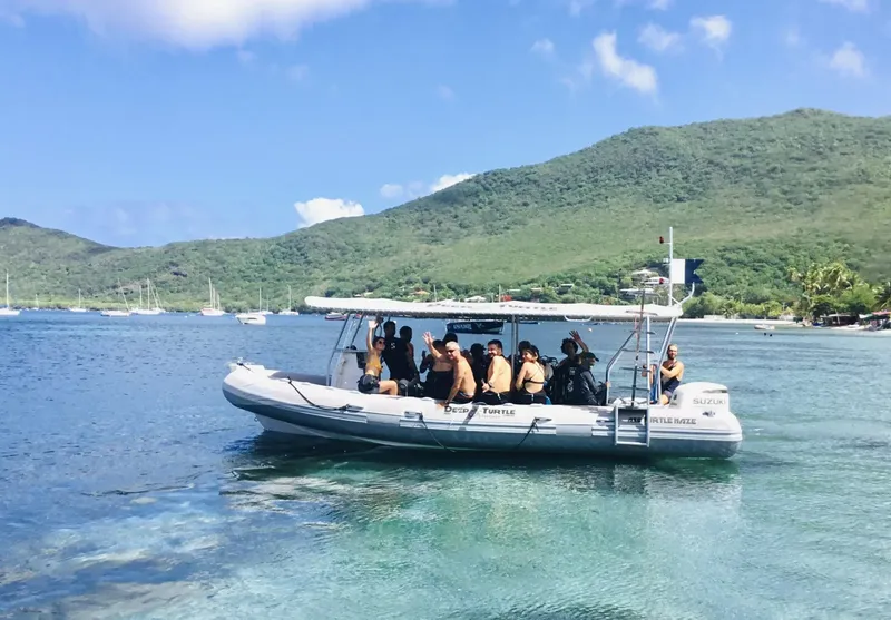 Groupe de plongeurs souriants sur un bateau semi-rigide en mer