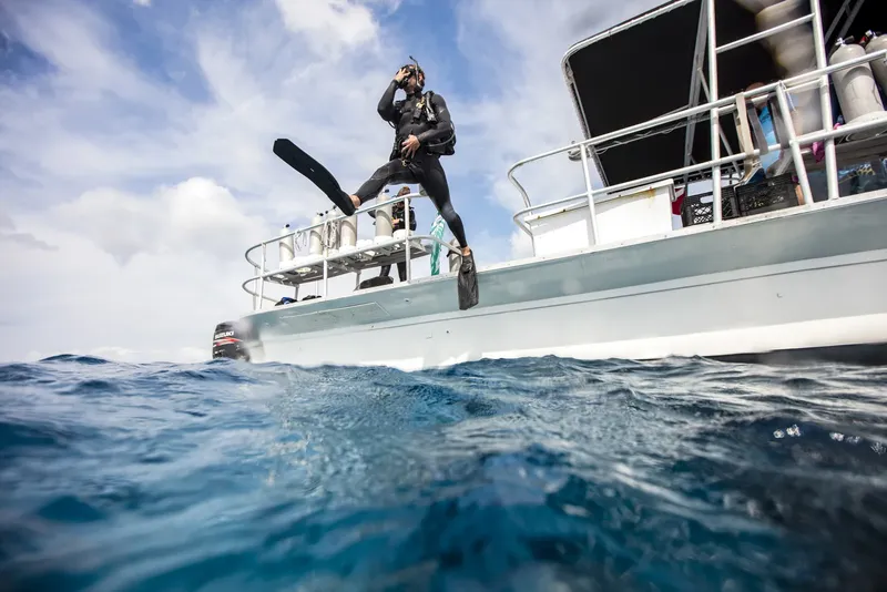 Plongeur s'apprête à sauter d'un bateau de plongée en pleine mer