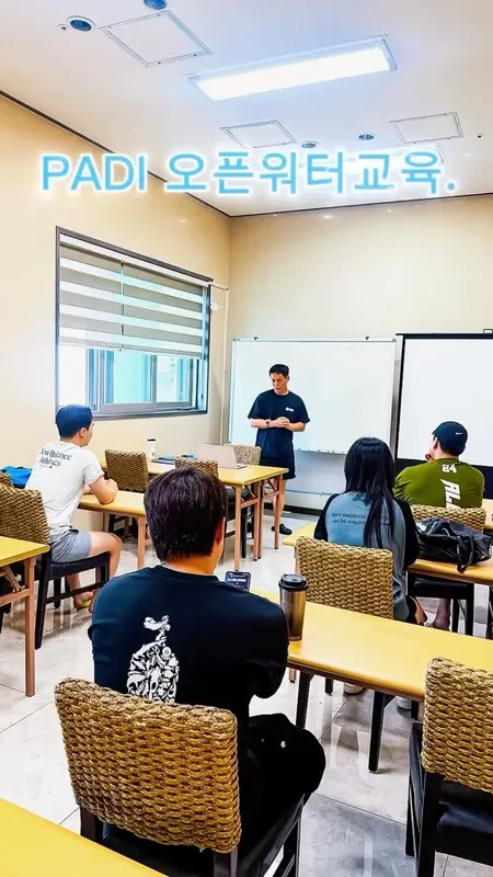 Cours de plongée en salle avec un instructeur et des étudiants