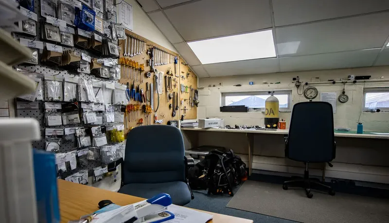 Atelier de réparation de matériel de plongée avec outils et bouteilles