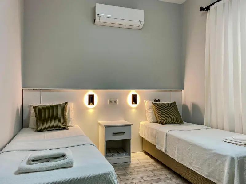 Une chambre avec deux lits simples et une décoration sobre.