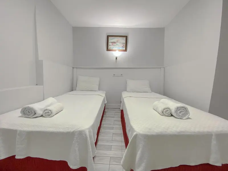 Deux lits simples dans une chambre lumineuse.