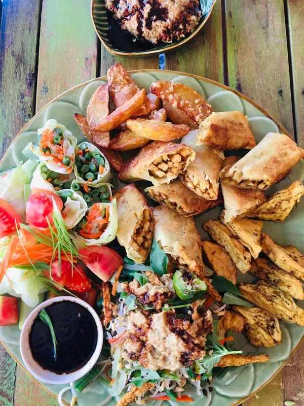 Assiette généreuse de beignets variés, de salade et de crudités.