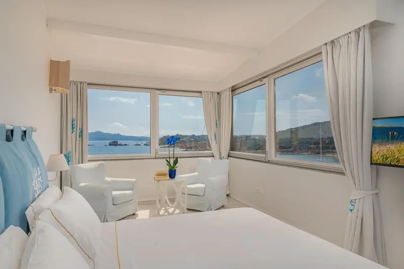 Chambre lumineuse avec vue sur la mer et coin salon.