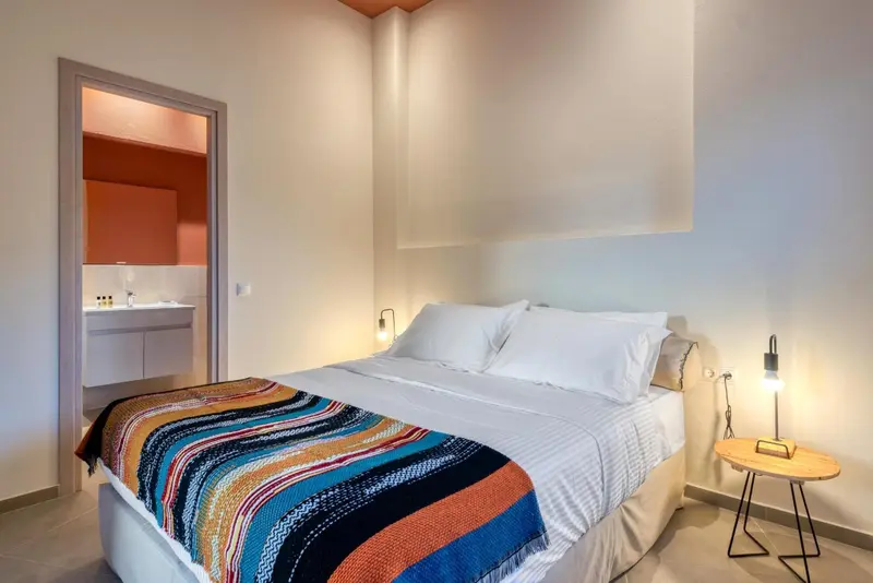 Une chambre lumineuse avec un grand lit et un accès à une salle de bain.