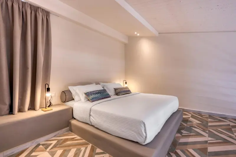Une chambre lumineuse avec un grand lit et des rideaux.