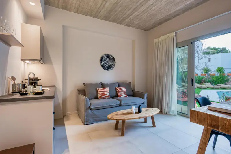 Espace de vie lumineux avec canapé et kitchenette.