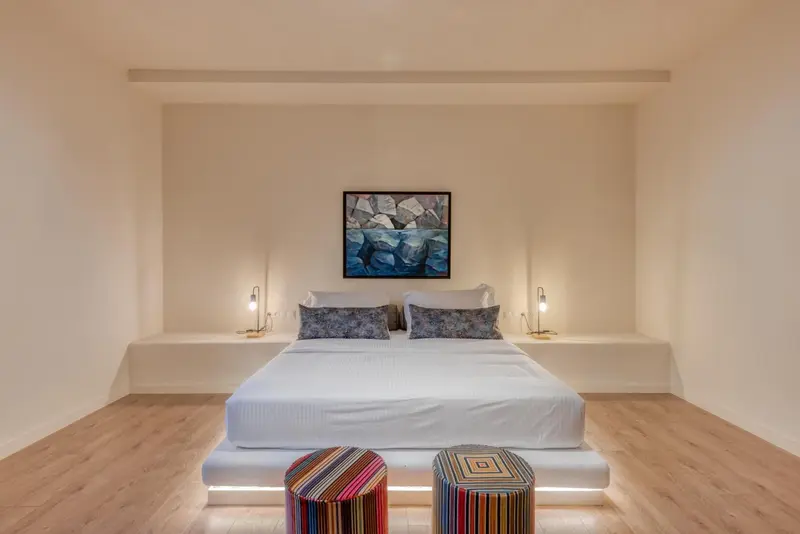 Une chambre lumineuse avec un grand lit et des tables de chevet.