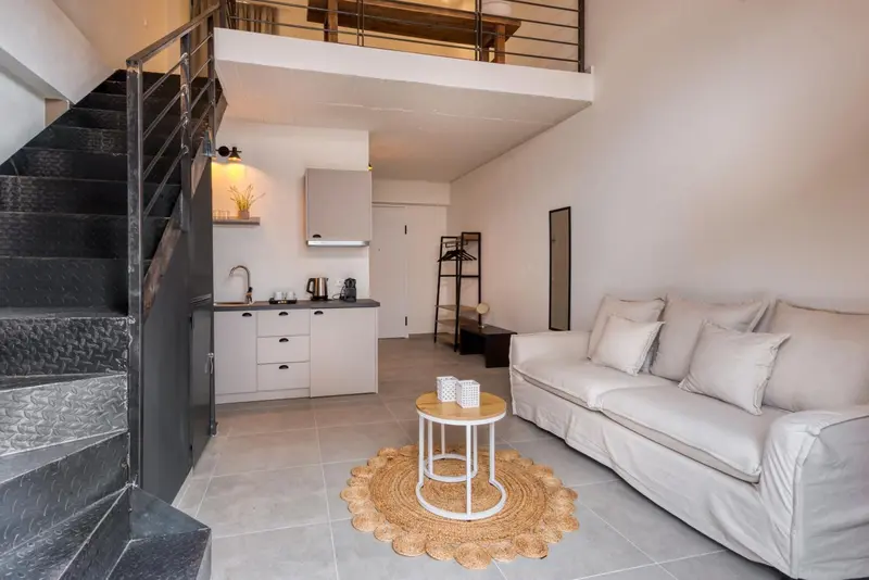 Espace de vie intérieur avec canapé et cuisine équipée.